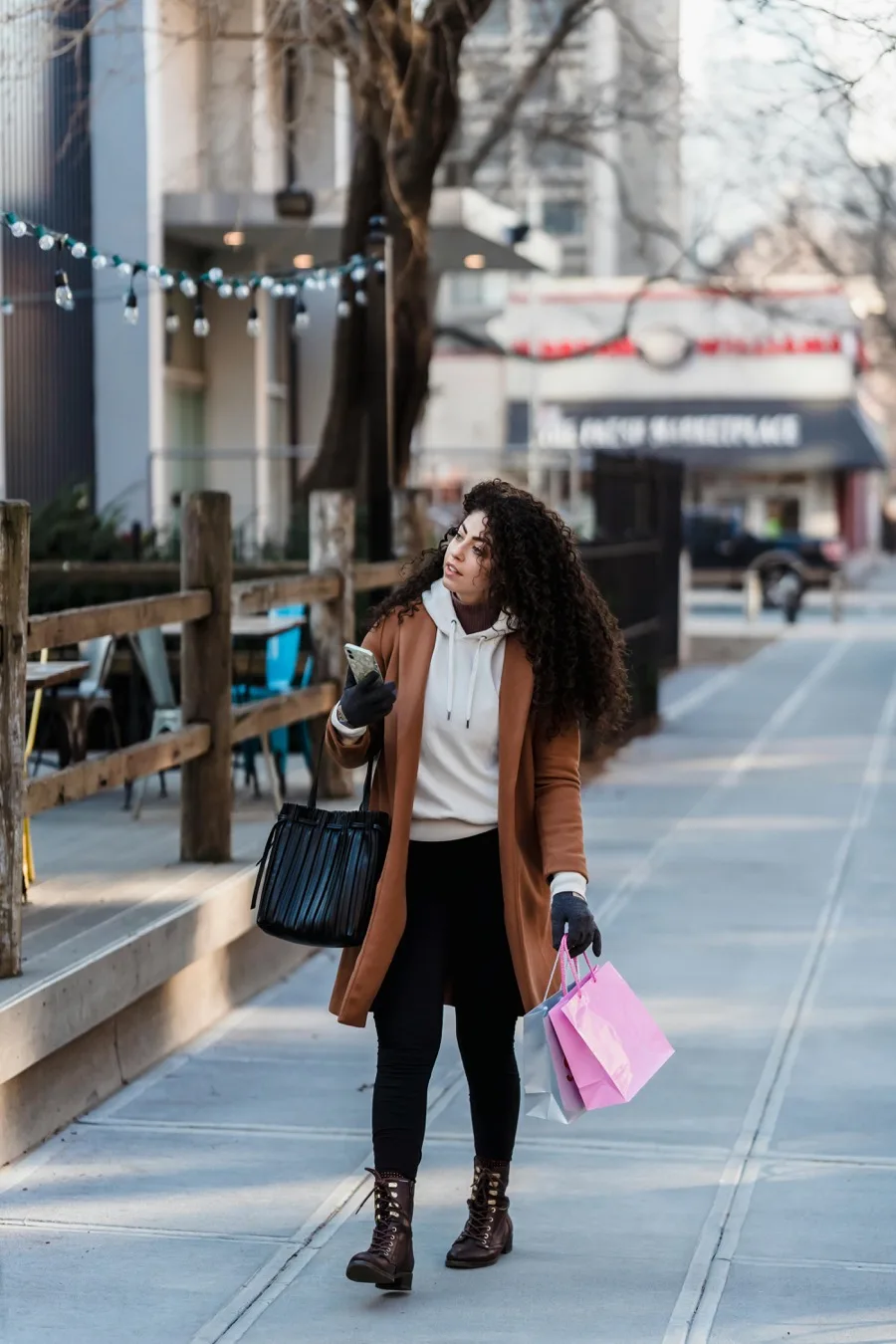 Tan coat over cream hoodie with black leggings